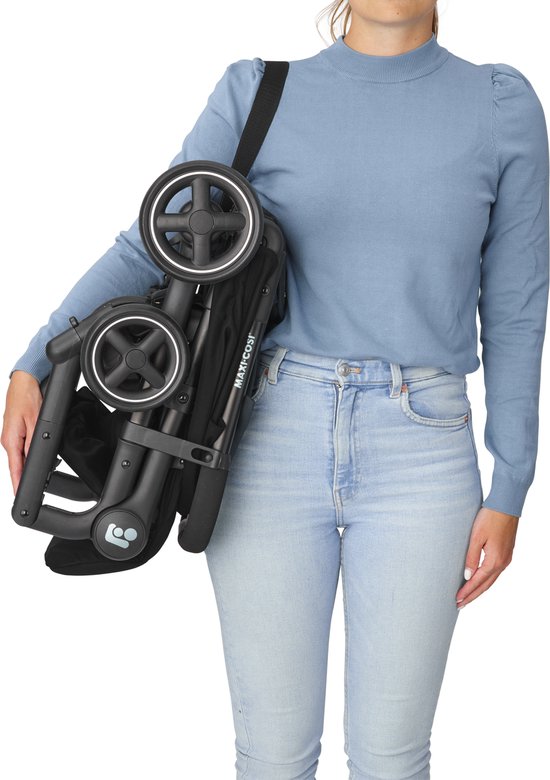 Vrouw draagt een ingeklapte zwarte Maxi-Cosi buggy over haar schouder.