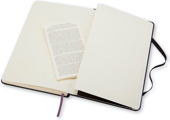 Zwart Moleskine notitieboek open met een fold-out informatieblad en paars lint bladwijzer.