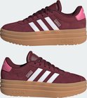 Twee bordeauxrode Adidas sneakers met witte strepen en dikke gum-zolen.
