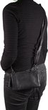 Zwarte leren clutch met franjes, gedragen als schoudertas door een model met jeans.
