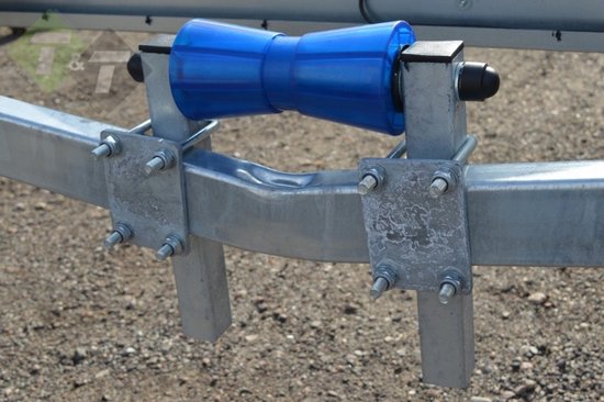 Galet de roulement bleu en plastique pour bateau sur un support de remorque argenté avec boulons.