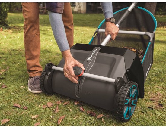 Een man stelt de Gardena bladverzamelaar in, met focus op de mechanische instellingen.