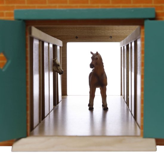 Paardenstal met rode bakstenen façade, groene deuren open, bruin paard in hal, wit paard in box.