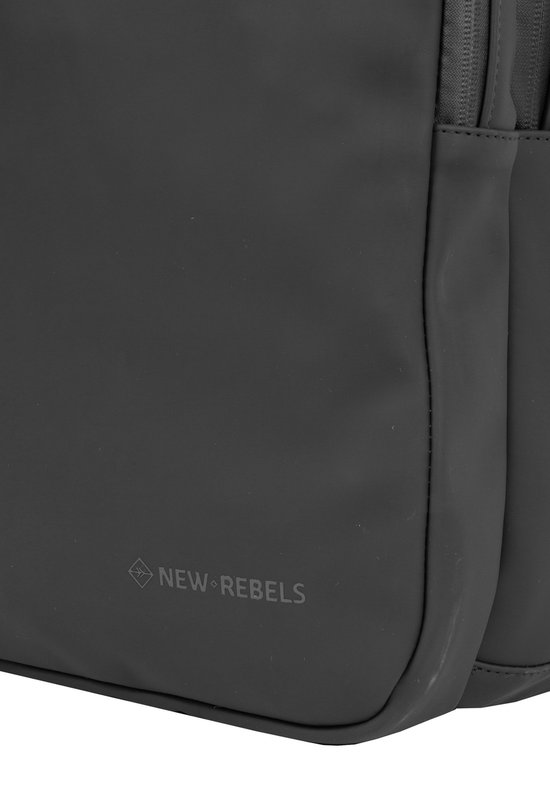 Detail van de hoek van een zwarte, waterafstotende rugzak met een subtiel 'NEW REBELS' logo.