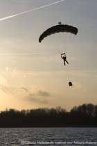 Schilderij Parachutist landing - Forex - Zonsondergang - 40 x 60 cm