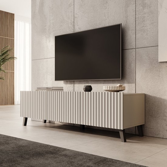 Beige TV-meubel Pepinos van 150 cm met geribbelde deuren en zwarte poten in een modern interieur.