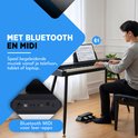 Man speelt op een Finesse piano met tablet op de houder. Bluetooth en MIDI ondersteuning.