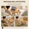 Vrouw gebruikt houten laptoptafel in bed, op de bank en op de vloer. De tafel kan worden aangepast voor werken, lezen en ontspannen.