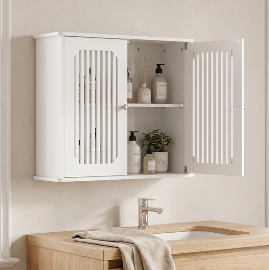 Wit medicijnkastje aan de muur met de deur open, gevuld met flacons en een plantje.