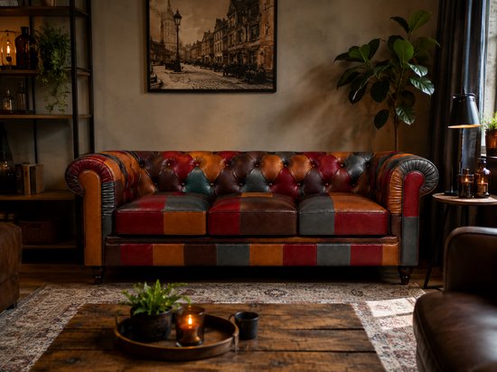 Een Chesterfield bank met knopen en patchwork panelen in rood, oranje, bruin en grijs leer.