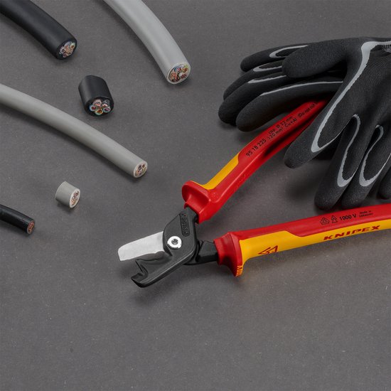 Knipex VDE stap-snij XL kabelschaar met gele, rode en zwarte handgrepen en een grijze kabel, ook met handschoenen.