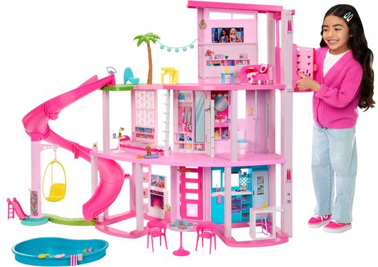 Roze Barbie poppenhuis met glijbaan, zwembad, meubels en een meisje dat het huis vasthoudt.