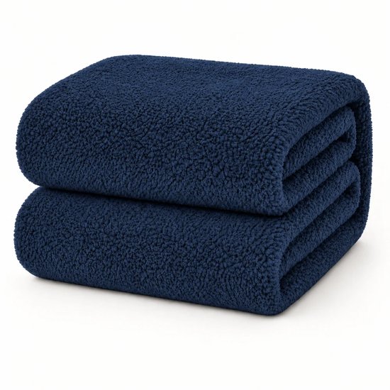 Twee opgevouwen donkerblauwe teddy hoeslakens op een witte achtergrond.