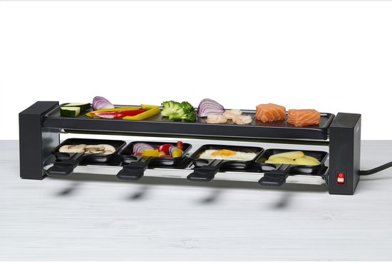 Zwarte raclette grill met bovenop courgette, paprika, ui, broccoli, garnalen en zalm. De pannetjes bevatten champignon, paprika, ei en aardappel.