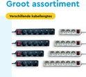 Assortiment witte en zwarte stekkerdozen met verschillende kabellengtes en rode schakelaars.