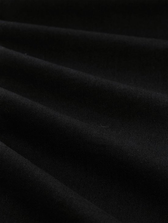 Een close-up van de zwarte denim stof van de Tom Tailor jeans.