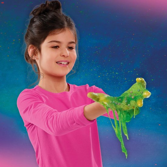 Meisje met roze shirt speelt met groen slijm met balletjes en gele accenten.