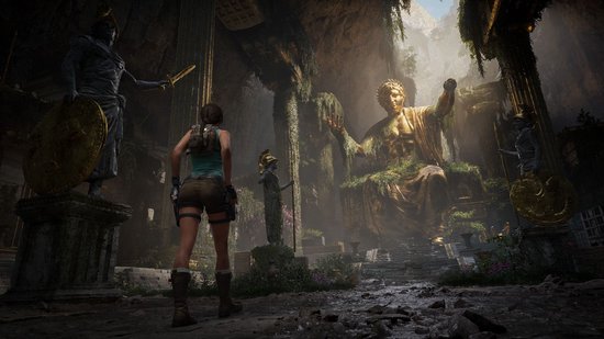 Lara Croft staat met haar rug naar de kijker in een verwoeste tombe met een enorm gouden standbeeld.
