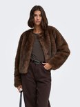 Model draagt een donkerbruin imitatiebont jack met lange mouwen en een ronde halslijn.