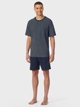 Model draagt een marineblauw T-shirt met stippenpatroon en bijpassende effen marineblauwe short.