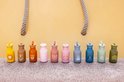 Rij van tien kleurrijke Trixie kinderdrinkflessen met verschillende dierenillustraties.