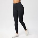 Zwarte sportlegging met hoge taille en witte sneakers.