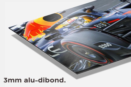 Detail van een Formule 1 raceauto in donkerblauw met gele neus en rode vlammen op de motorkap.