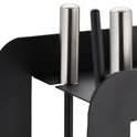 Detailopname van de zilverkleurige handvatten en zwarte metalen houder van de haardset.