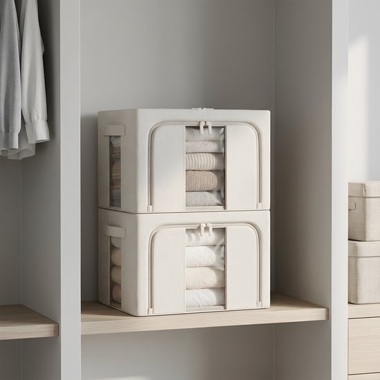 Twee beige opvouwbare opbergboxen gestapeld op een houten plank met kleding zichtbaar door de transparante vensters.