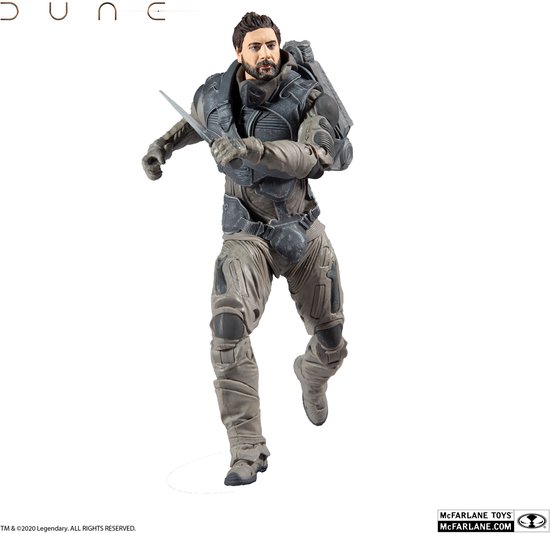 Dune actiefiguur in een dynamische hardloophouding met mes, drager van een grijs harnas en rugzak.