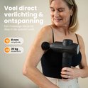 Een vrouw gebruikt een zwarte massagegun op haar arm, 8mm amplitude, 20kg druk.