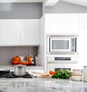 Grote roestvrijstalen HcB kookpan op een kookplaat in een moderne keuken.