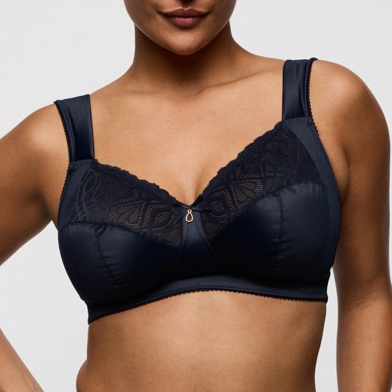 Model draagt een donkerblauwe beugel-loze bh met kanten details op de cups.