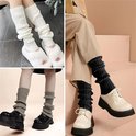Dames in witte, grijze en zwarte beenwarmers met verschillende schoenen en kleding.