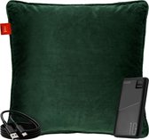 Donkergroen fluwelen kussen met een zwarte powerbank en USB-C kabel.
