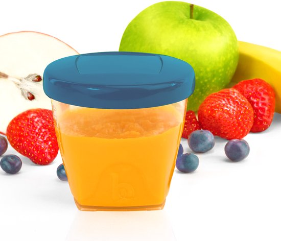 Gevuld bewaarbekertje met sinaasappelsap omringd door fruit: aardbeien, bosbessen, groene appel en banaan.