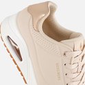 Gros plan d'une basket Skechers couleur naturelle avec détail doré au talon et perforations.