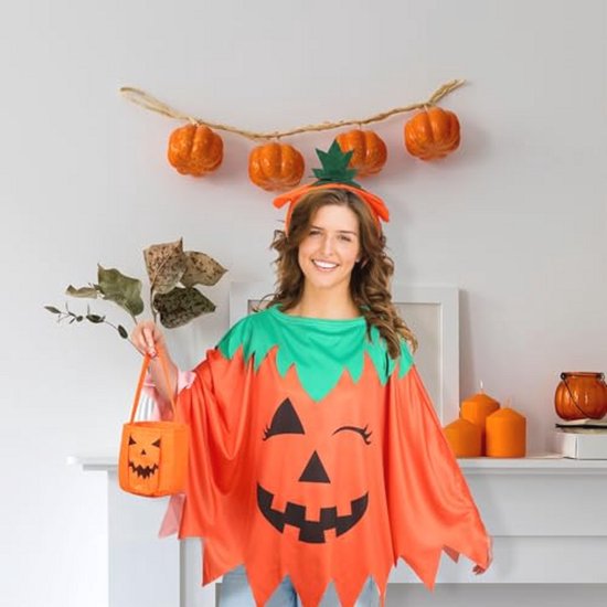 Vrouw in pompoencape, met oranje lantaarns en een pompoenslinger aan de muur in de achtergrond.