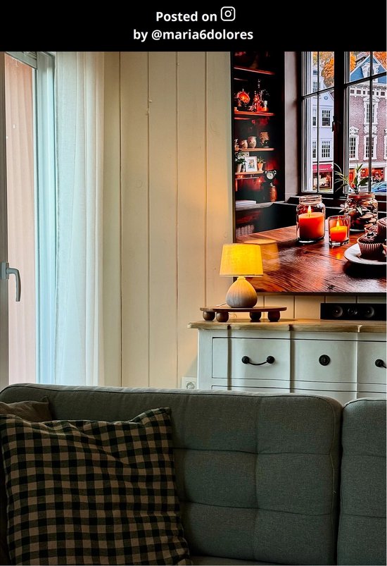 Petite lampe de table avec base grise et abat-jour orange sur un buffet.