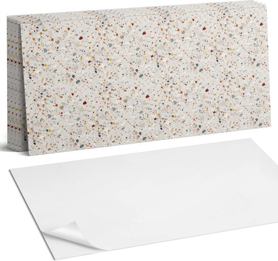 Stapel beige zelfklevende tegels met een terrazzo-patroon en een los vel wit papier ernaast.