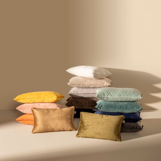 Pile de coussins décoratifs de différentes couleurs, dont jaune, orange, rose, vert et bleu, à la texture velours.