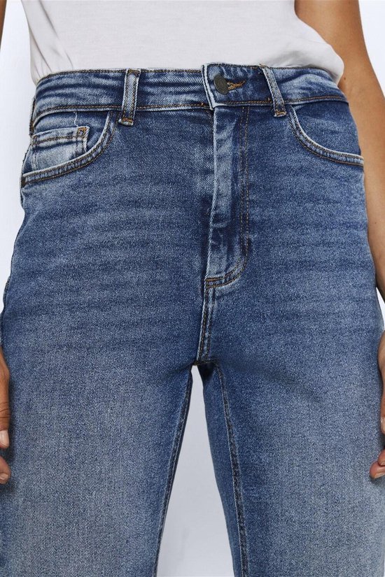 Close-up van de tailleband en knoopsluiting van een blauwe stonewashed jeans.
