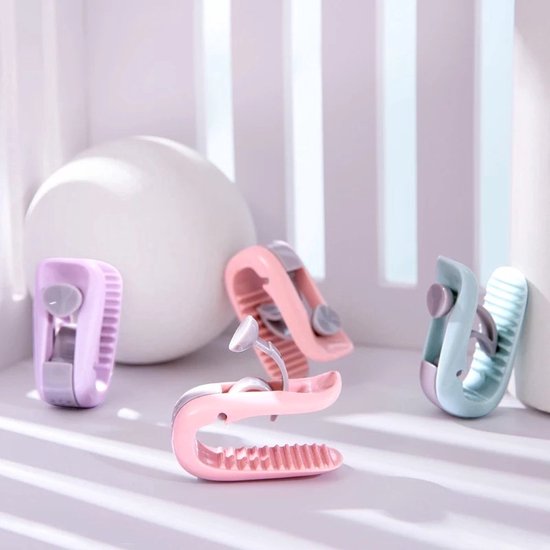 Vier dekbedclips in pastelkleuren (lichtpaars, roze, lichtblauw) op een zachtroze ondergrond.
