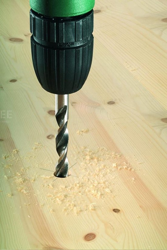 Tête de perceuse fore dans une planche de bois, des copeaux de bois volent.