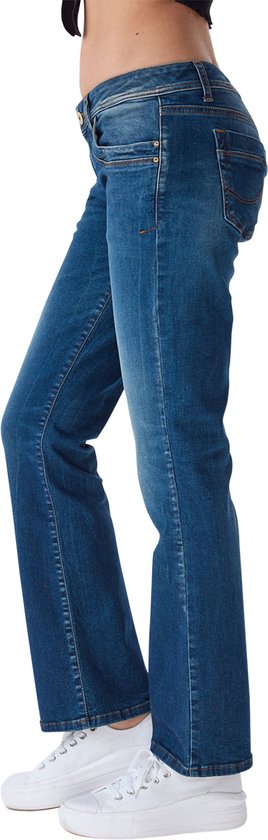 Zijaanzicht van een model in een blauwe bootcut jeans met lichte vervaging op de bovenbenen.