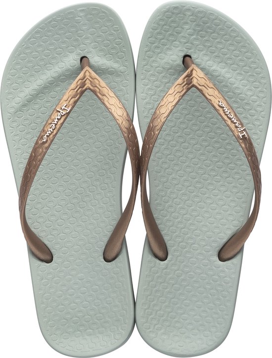 Paar lichtgroene Ipanema slippers met koperkleurige bandjes.