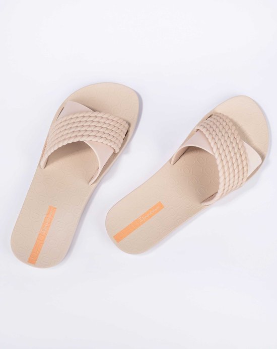 Lichtbruine Ipanema slippers met gevlochten band en oranje detail op de zool.