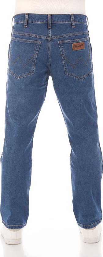 Blauwe Wrangler jeans, met bruin leren label op de achterkant en oranje stiksels.
