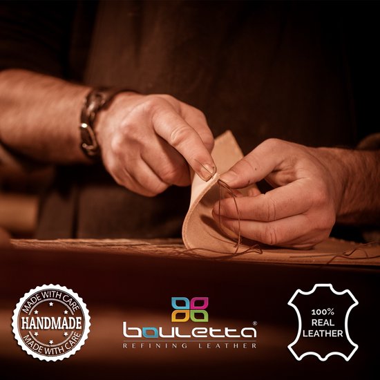Mains d'un artisan cousant du cuir avec une aiguille et du fil.
