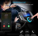 Een persoon in een auto die een telefoon beantwoordt, naast een zwarte FM-zender met een digitaal scherm met nummerweergave.